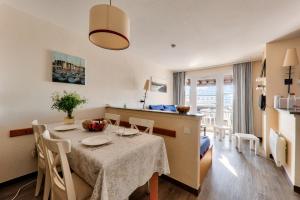 アルゾンにあるAppartement vue mer à 400m de la plage du Fogeoのテーブルと椅子のあるキッチンとダイニングルーム