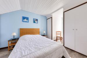 アルゾンにあるAppartement vue mer à 400m de la plage du Fogeoの青い壁のベッドルーム1室(大型ベッド1台付)