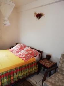 a small bedroom with a bed and a chair at Studio Griyav- dans villa les Polycias in Sainte-Luce
