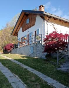 a large white house with a porch and a brick wall at Ca' Valentina in Netro