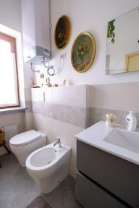 a white bathroom with a toilet and a sink at Ca' Valentina in Netro