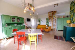 a living room with a table and colorful chairs at Ca' Valentina in Netro +4 photos