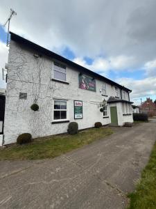 a white building with a sign on the side of it at The Olivia Swan in Deighton