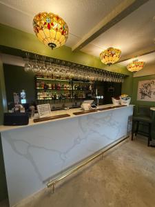 a bar in a restaurant with two chandeliers at The Olivia Swan in Deighton