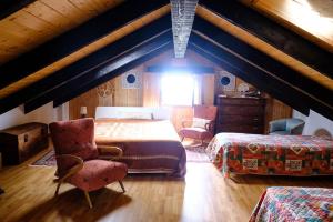 a attic bedroom with a bed and a chair at Ca' Valentina in Netro