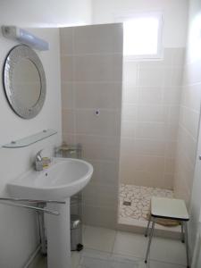 a white bathroom with a sink and a mirror at soulac sur mer maison proche du marche in Soulac-sur-Mer
