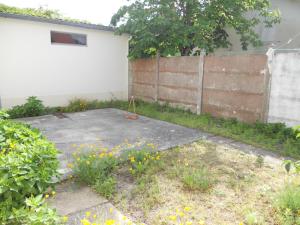 a yard with a fence and some flowers at soulac sur mer maison proche du marche in Soulac-sur-Mer +2 photos