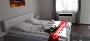 a bedroom with a white bed with christmas decorations on it at Arcanum Apartman in Makó