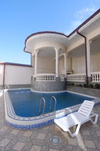a swimming pool with a chair and a house at Oscar in Samarkand