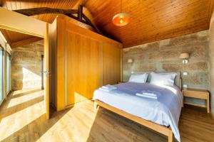 a bedroom with a bed and a wooden ceiling at Quinta de Casal do Bairro - Casa do Alpendre in Guimarães