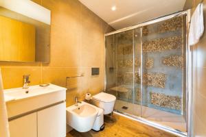 a bathroom with a shower and a toilet and a sink at Quinta de Casal do Bairro - Casa do Alpendre in Guimarães +28 photos