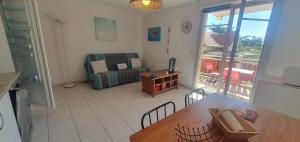 una sala de estar con un sofá y una mesa en appartement residence les vagues, en Soulac-sur-Mer