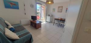 Sala de estar con cama y mesa con TV en appartement residence les vagues, en Soulac-sur-Mer