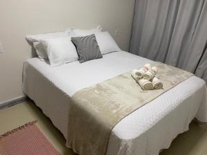 a bed with two pairs of slippers on it at Casa Bella Collina in Venda Nova do Imigrante