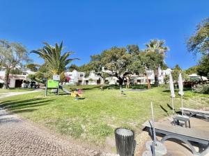 a park with a child playing in the grass at Albufeira Balaia Golf Vilage 2 With Pool by Homing in Albufeira