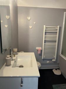 a bathroom with a sink and a mirror with hearts on the wall at La bulle - Font-Romeu in Font-Romeu
