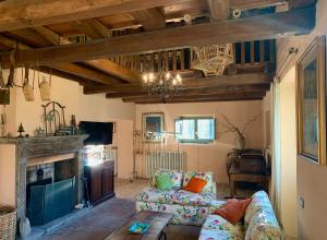Una sala de estar con un sofá y una chimenea. en NoxRomana Beautiful Casale in Tuscia, en Capranica