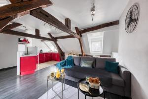 a living room with a couch and a table at La Nuit du Drouais in Dreux