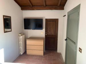 Habitación con TV en la pared y puerta en NoxRomana Beautiful Casale in Tuscia, en Capranica