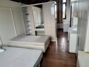 a room with two beds and a mirror at Casarão temporada verão - Propriedade do Hotel Matos in Capão da Canoa