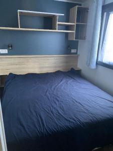 a bed in a bedroom with a blue blanket at MH 3CH à l'océan Landais chez Claiclé in Saint-Julien-en-Born +13 photos