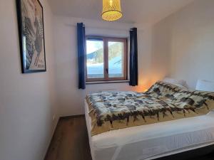 ein Schlafzimmer mit einem Bett und einem Fenster in der Unterkunft Appartement 3 Pièces, 6 Pers, Parking couvert - FR-1-291-1025 in Valmorel