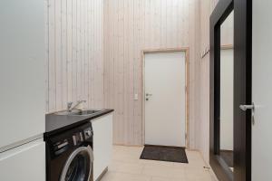 - une buanderie avec un évier et un lave-linge dans l'établissement Beautiful And Well-Designed Holiday Home With Sea View, Spacious Terraces And Spa Just 200 Metres From The Child-Friendly Femmøller Beach And Close, à Ebeltoft