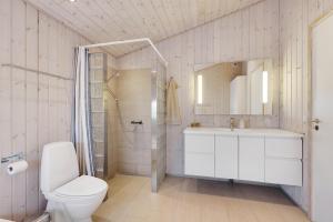 une salle de bain avec toilettes, lavabo et douche dans l'établissement Beautiful And Well-Designed Holiday Home With Sea View, Spacious Terraces And Spa Just 200 Metres From The Child-Friendly Femmøller Beach And Close, à Ebeltoft 17 autres photos