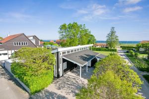 vue aérienne d'une maison avec un toit dans l'établissement Beautiful And Well-Designed Holiday Home With Sea View, Spacious Terraces And Spa Just 200 Metres From The Child-Friendly Femmøller Beach And Close, à Ebeltoft
