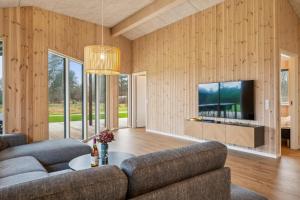 ein Wohnzimmer mit Sofa und Fernseher in der Unterkunft Beautiful And Modern 8-Person Holiday Home With Spacious Terraces And Quality Interiors Located In Peaceful Fuglslev Close To Forest, Nature And in Ebeltoft