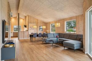 ein Wohnzimmer mit Sofa und Tisch in der Unterkunft Beautiful And Modern 8-Person Holiday Home With Spacious Terraces And Quality Interiors Located In Peaceful Fuglslev Close To Forest, Nature And in Ebeltoft