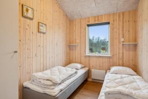 zwei Betten in einem Zimmer mit Fenster in der Unterkunft Beautiful And Modern 8-Person Holiday Home With Spacious Terraces And Quality Interiors Located In Peaceful Fuglslev Close To Forest, Nature And in Ebeltoft