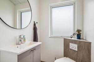 ein Badezimmer mit Waschbecken und Spiegel in der Unterkunft Beautiful And Modern 8-Person Holiday Home With Spacious Terraces And Quality Interiors Located In Peaceful Fuglslev Close To Forest, Nature And in Ebeltoft + 17 Fotos