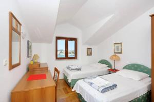 um quarto com 2 camas, uma mesa e uma secretária em Apartment Sara em Pirovac