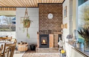 a patio with a brick fireplace and a clock on a wall at Gorgeous Home In Vinderup With Wifi in Vinderup