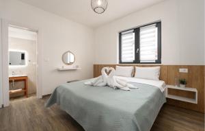 a bedroom with a bed with two swans on it at Gorgeous Home In Jursici With Wifi in Juršići