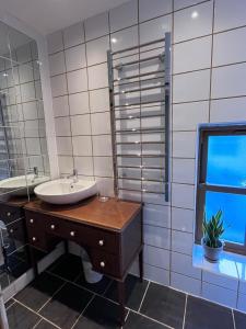 a bathroom with a sink and a mirror and a window at Claires Cottage in Bethesda