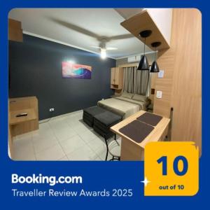 Habitación con 1 dormitorio con 2 camas y mesa. en kitnet Premium ao lado da praia Canto do Forte, en Praia Grande