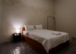 a bed in a room with a lamp on a table at Aayu Pantai - George Town, Penang in George Town