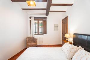 a bedroom with a bed and a chair in it at Cueva Del Gollisno in Chulilla