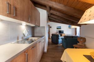 a kitchen with a sink and a couch in a room at Ferienwohnung Hünten in Oberstdorf