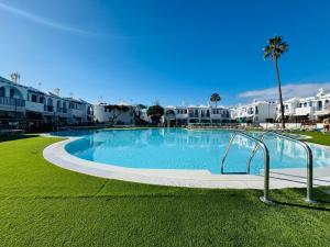 a large swimming pool with buildings in the background at Bungalow Gilly in Maspalomas