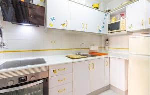 eine Küche mit weißen Schränken und einer Spüle in der Unterkunft Beautiful Apartment In San Javier in San Javier