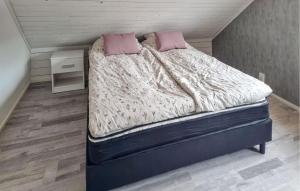a bed with two pink pillows on it in a room at Awesome Apartment In Mullsjö With Wifi in Mullsjö