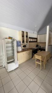 a kitchen with a refrigerator and a table in it at Casa na Praia - 180m do mar in São Francisco do Sul