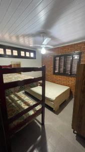 a room with two bunk beds and a ceiling at Casa na Praia - 180m do mar in São Francisco do Sul