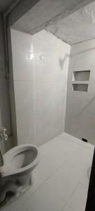 Habitación blanca con baño y aseo. en Shriji Home stay, en Mathura 15 fotos más