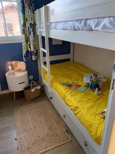 a bedroom with a bunk bed with a yellow bedspread at Maison avec jardin à Lacanau – 54 m² in Lacanau +37 photos