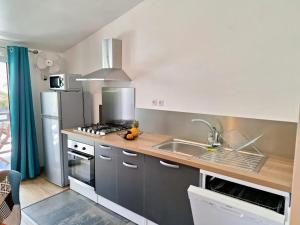 a kitchen with a sink and a stove top oven at Studio cosy avec vue sur mer à Saint-Leu, 31 m² in Saint-Leu +6 photos