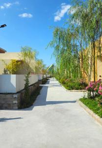 a walkway in a yard with flowers and trees at Sunrise Resort & Cafe - ซันไรส์ รีสอร์ท & คาเฟ่ in Nakhon Phanom